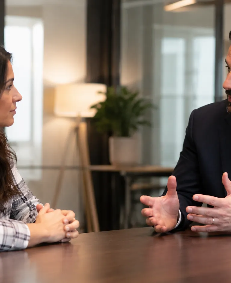 Employee discussing a workplace dispute and potential compensation with an employment lawyer in a modern office.
